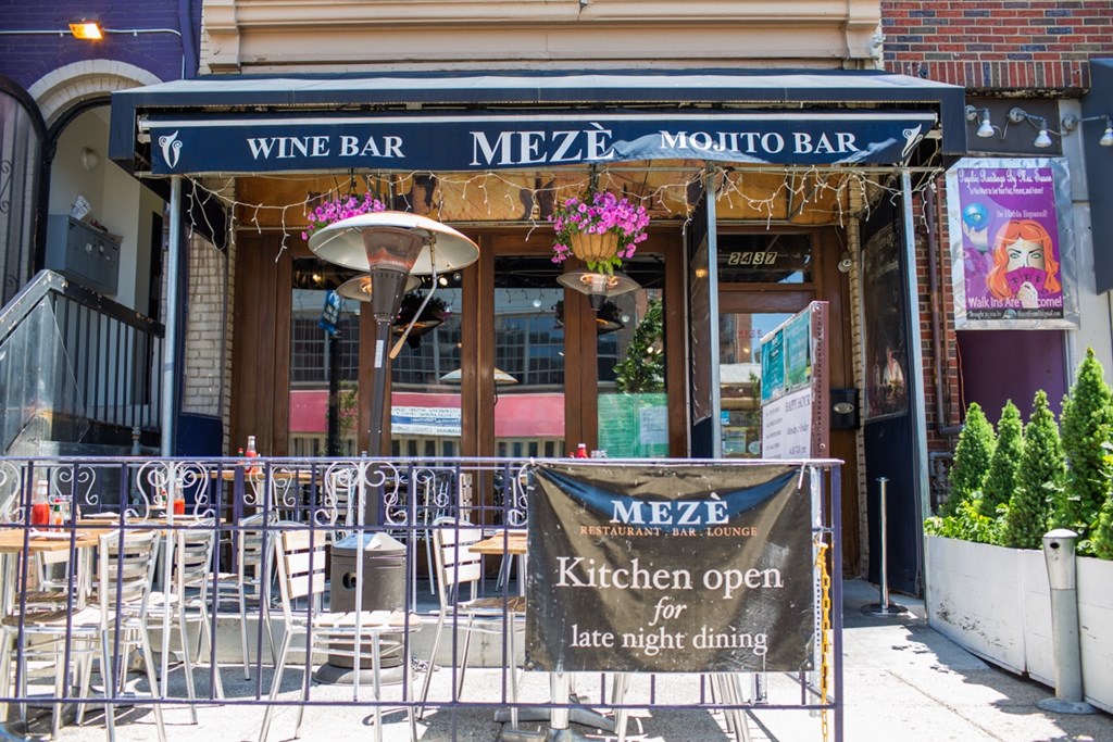 A sign in front of a restaurant advertises that the kitchen is open for late night dining.