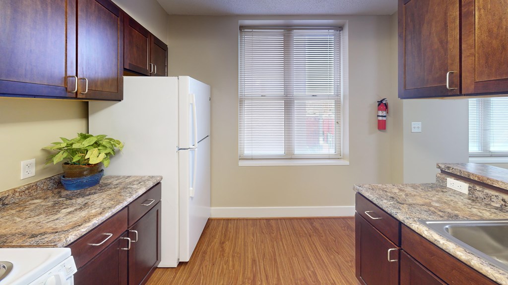 A kitchen with brown cabinets and a white fridge.