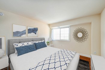 bedroom with bed, nightstand, hardwood flooring and window at naylor overlook apartments in washington dc - Photo Gallery 2