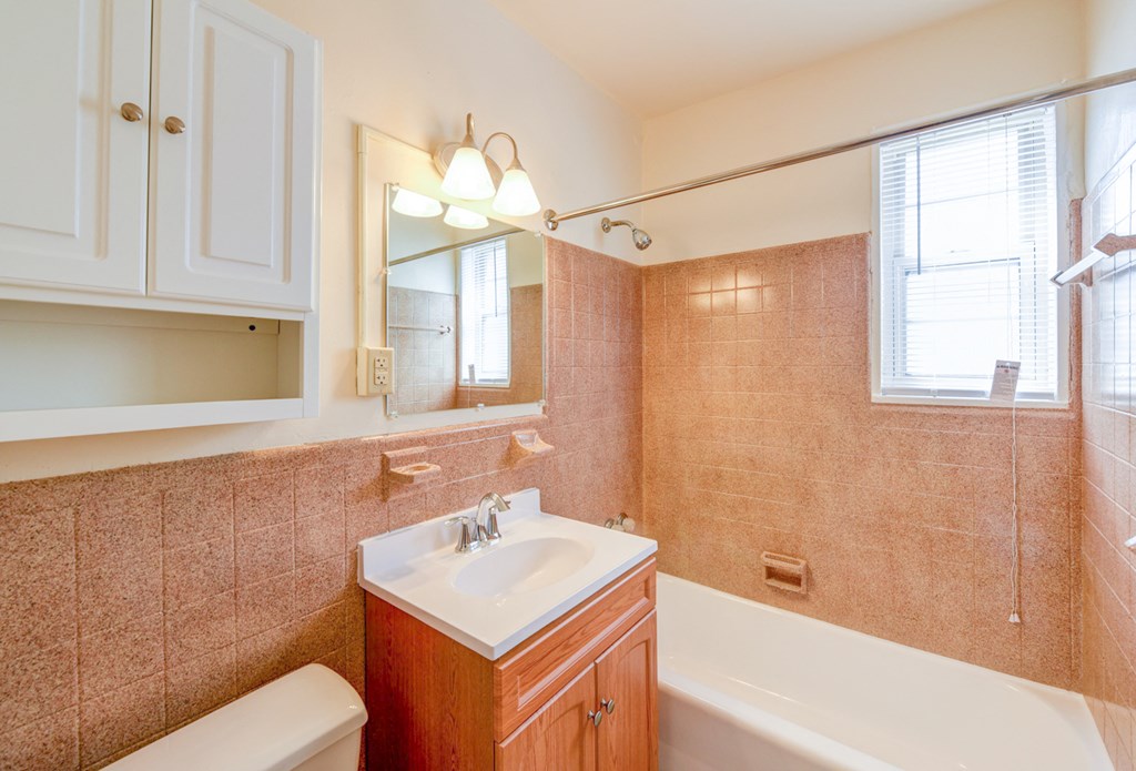 bathroom with tub, vanity, large mirror and tile details at new horizon apartments in washington dc