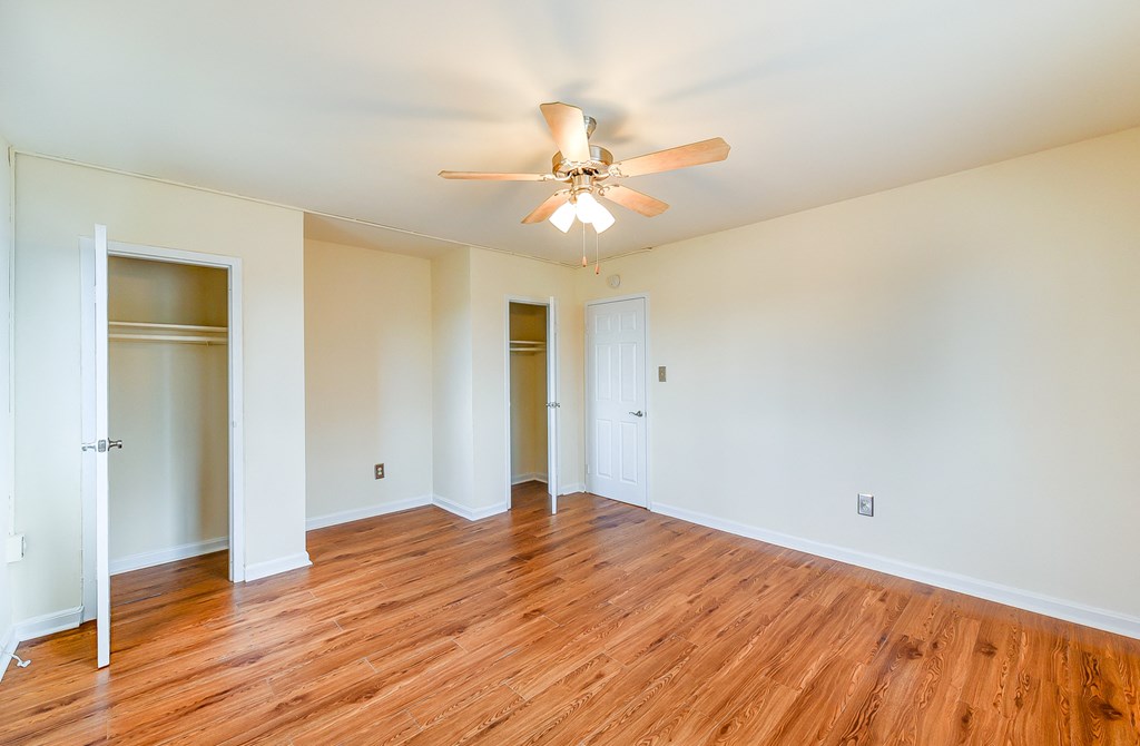 vacant bedroom with hardwood floors, ceiling fan, and large closet at new horizon apartments in washington dc