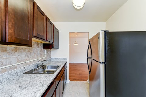 full kitchen with stainless steel appliances and wood cabinets in an apartment