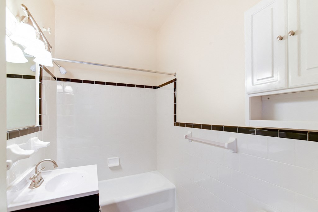bathroom with sink, mirror, cabinet, tub and tile details at norwood apartments in washington dc