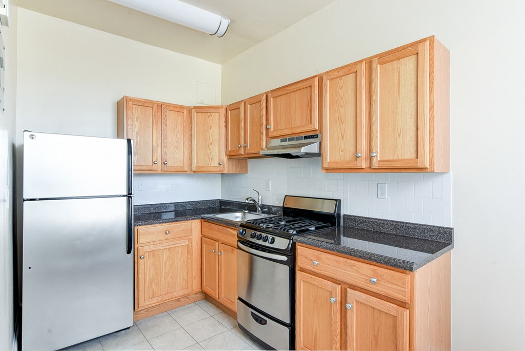 kitchen with stainless steel appliances and wood cabinetry at norwood apartments in washington dc