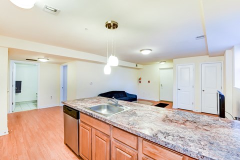 open kitchen with large kitchen island, hardwood floors, and view of living area at park vista apartments in washington dc