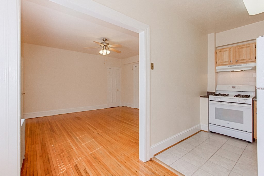 kitchen with wood cabinetry, gas range and view of living area at parkside apartments in washington dc