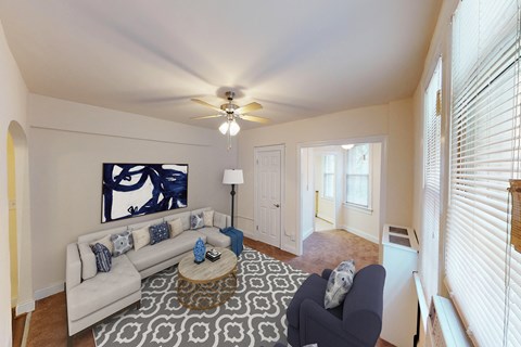 a living room with a white couch and a ceiling fan