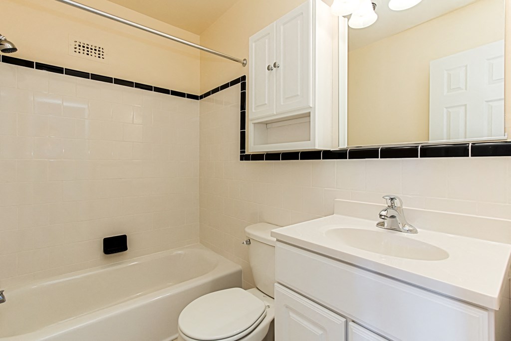 bathroom with tub, toilet, mirror, sink, medicine cabinet and tile details at penn view apartments in washington dc