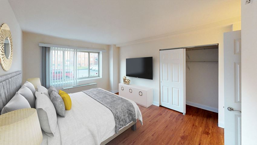 bedroom with bed, dresser, large window, closet and hardwood flooring at penn view apartments in washington dc - Photo Gallery