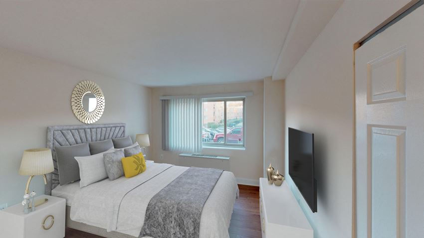 bedroom with bed, nightstands, dresser, tv and large windows at penn view apartments in washington dc - Photo Gallery