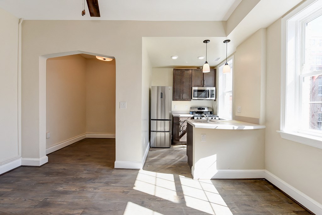 kitchen with espresso cabinetry, breakfast bar and stainless steel appliances at petworth station apartments in washington dc