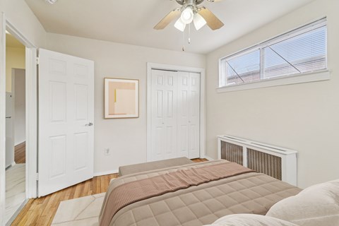 A bedroom with a large bed and a ceiling fan.
