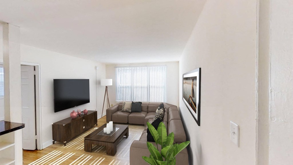 living room with windows, tv, sofa, and coffee table