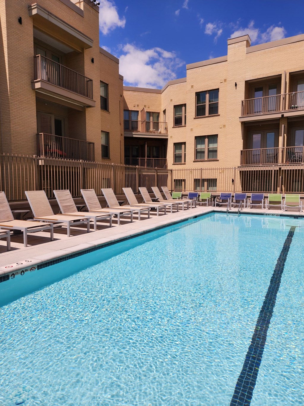 a large swimming pool in front of an apartment building