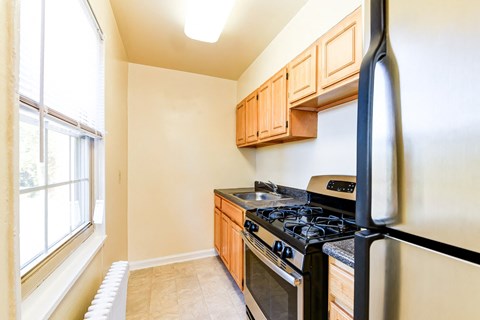 a kitchen with a stove and refrigerator and a window