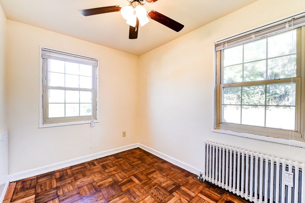 vacant bedroom with hardwood flooring and ceiling fan at the richman apartments in washington dc