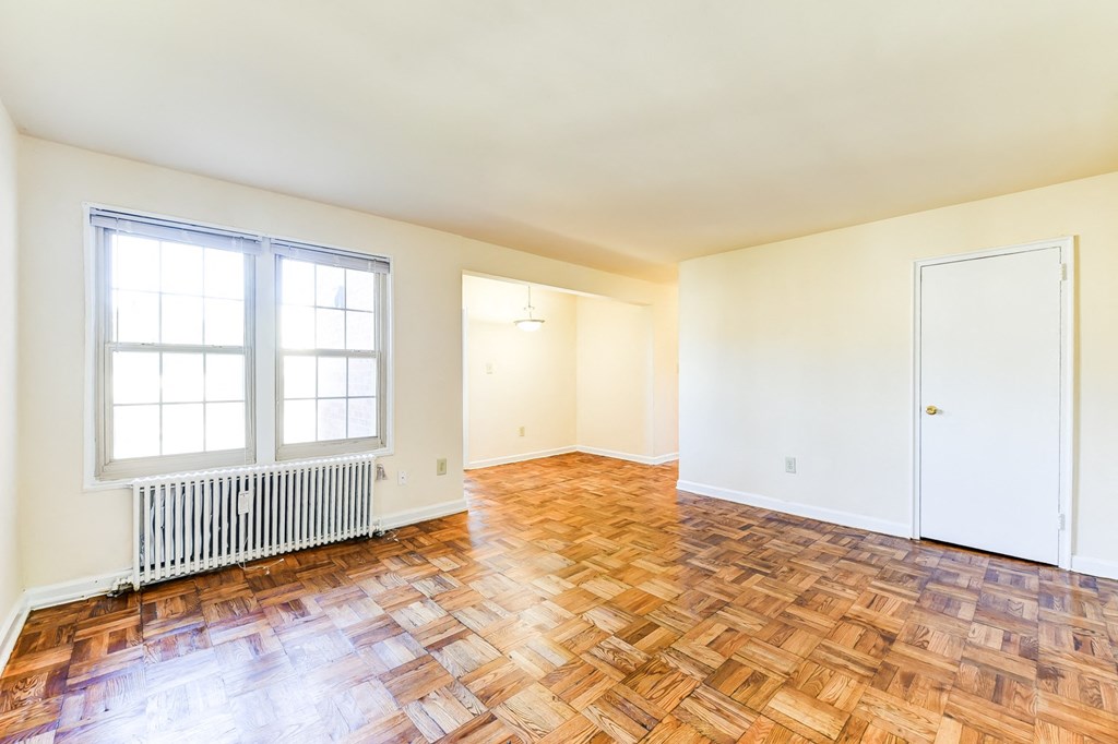 vacant living area with hardwood flooring and large windows at richman apartments in washington dc