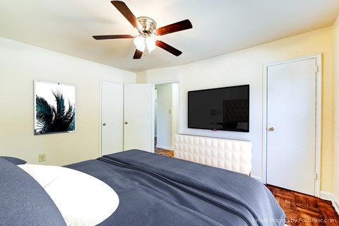 bedroom with bed, closet, dresser, wood floor and ceiling fan at the richman apartments in congress heights washington dc