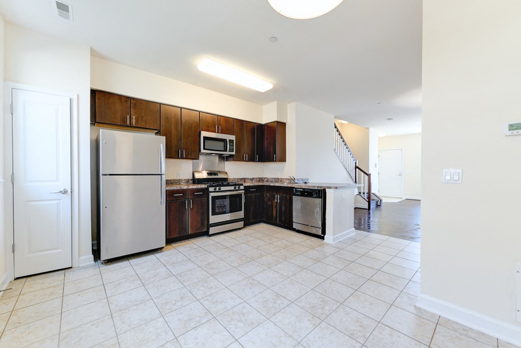 kitchen with espresso cabinetry, view of dining area and stainless steel appliances at sheridan station south townhomes in washington dc