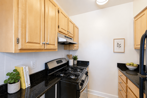 A kitchen with wooden cabinets and a black countertop.