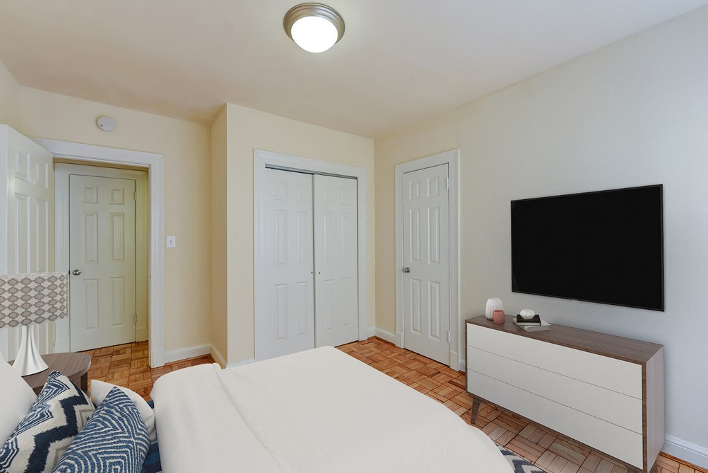 Bedroom with bed, dresser, tv, and large closet at sherry Hall apartments in washintgon dc