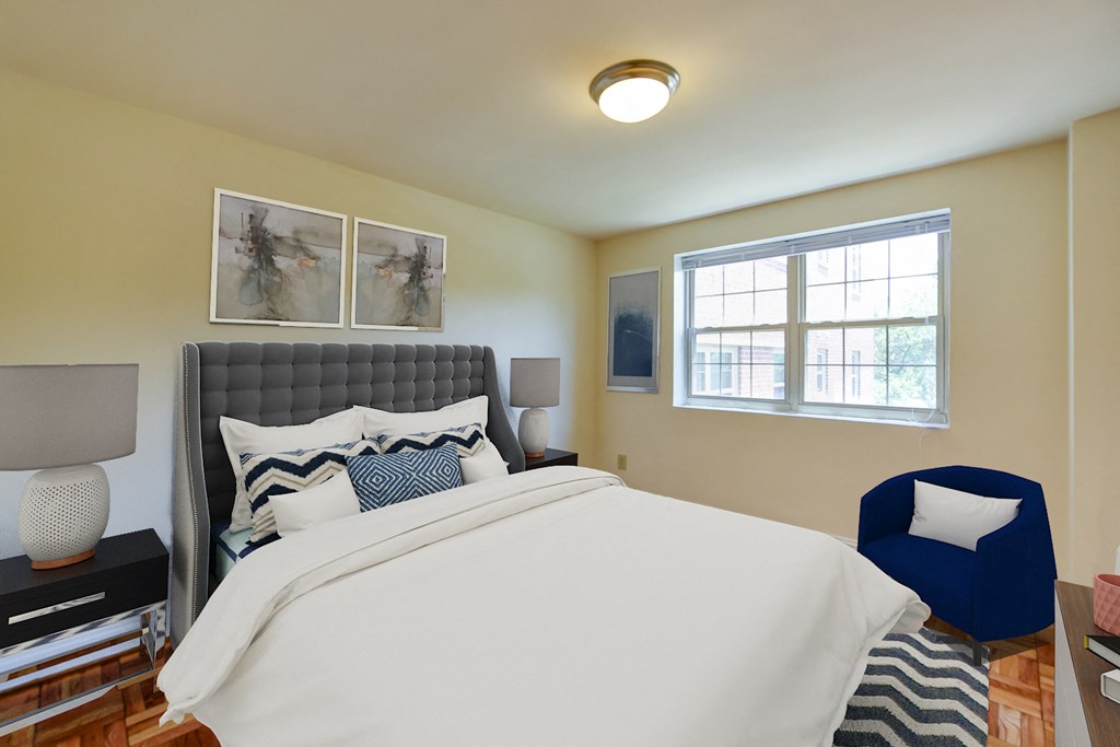 bedroom with bed, nightstands, parquet flooring and large window at shipley park apartments in washington dc
