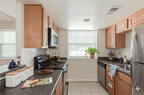 A kitchen with wooden cabinets and a black stove top oven.