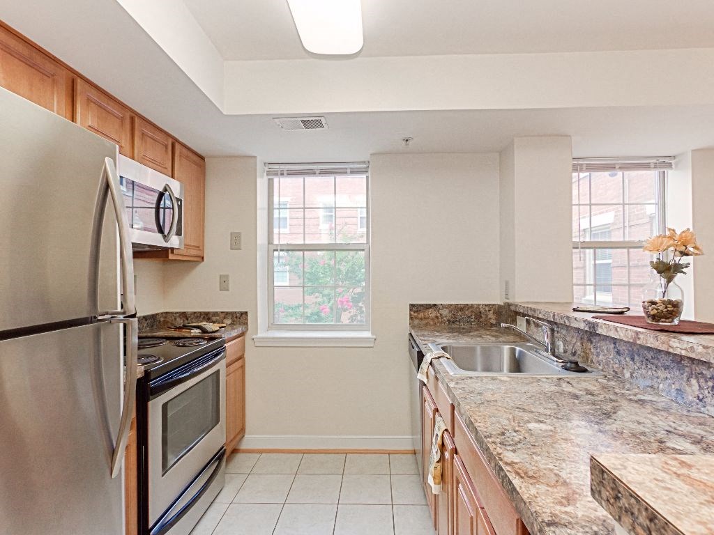 kitchen with stainless steel appliances, window and breakfast bar at the oaks apartments in washington dc