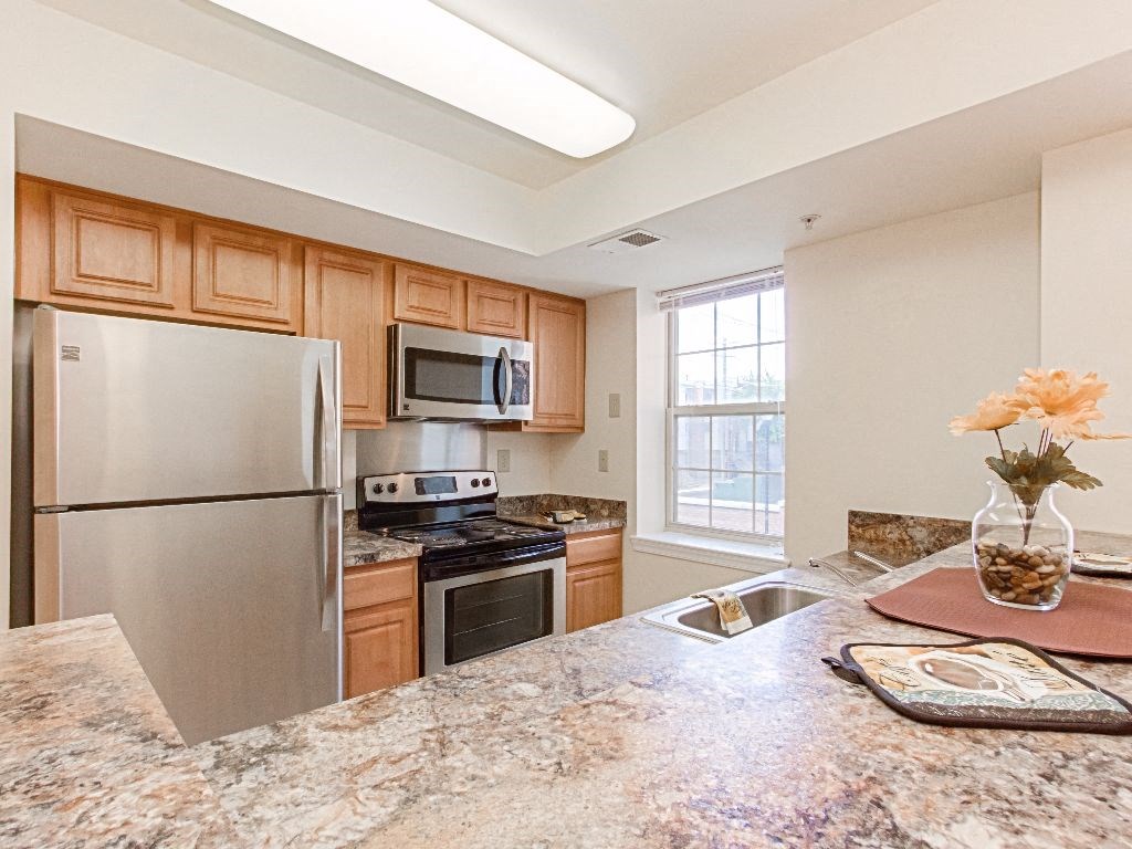 kitchen with stainless steel appliances and breakfast bar at the oaks apartments in washington dc