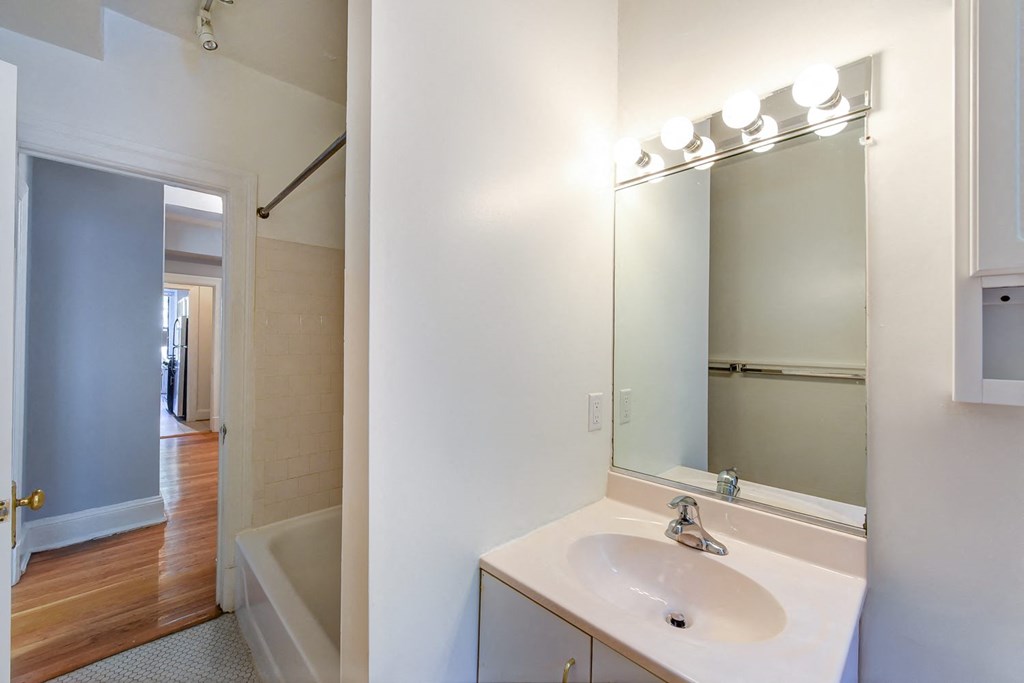 bathroom with vanity, mirror, tub and view of hallway at the shawmut apartments in adams morgan washington dc