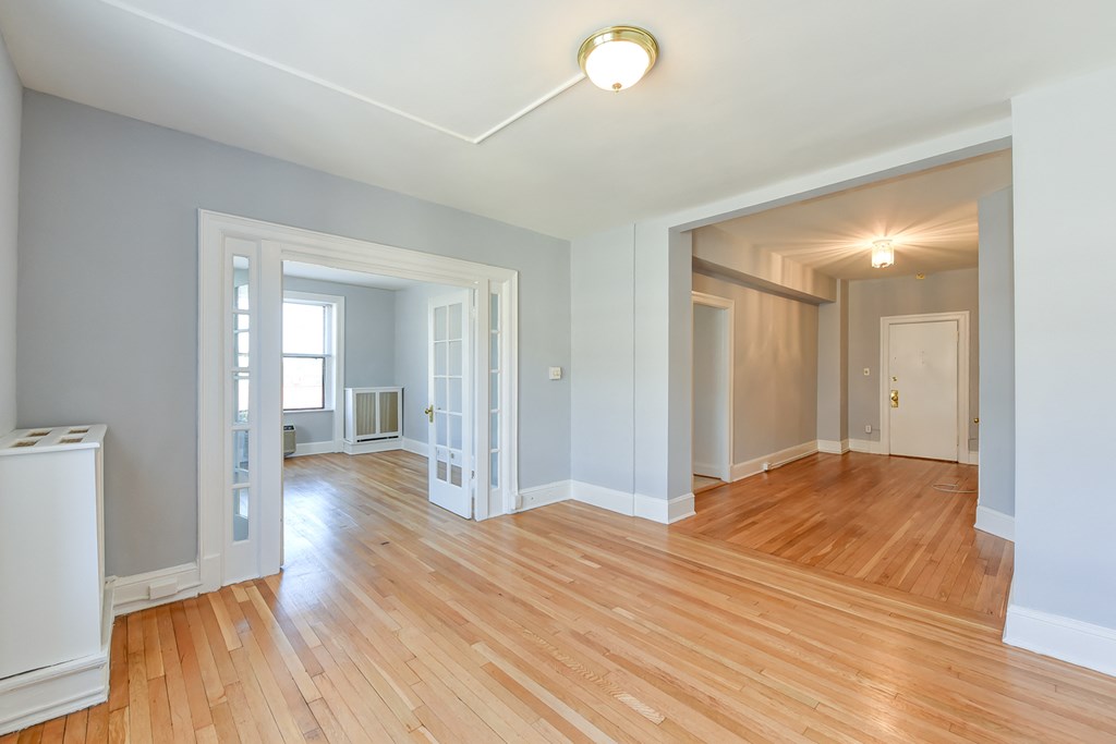 vacant living area with hardwood floors, french doors and view of foyerat the shawmut apartments in washington dc