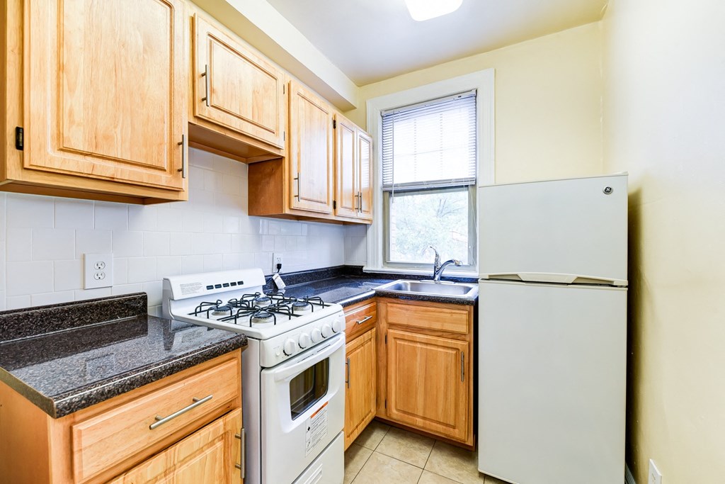 kitchen with gas range, wood cabinetry and energy efficient appliances at the foreland apartments in washinton dc