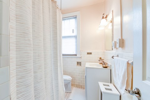 bathroom with toilet, tub, vanity and mirror at the foreland apartments in washington dc