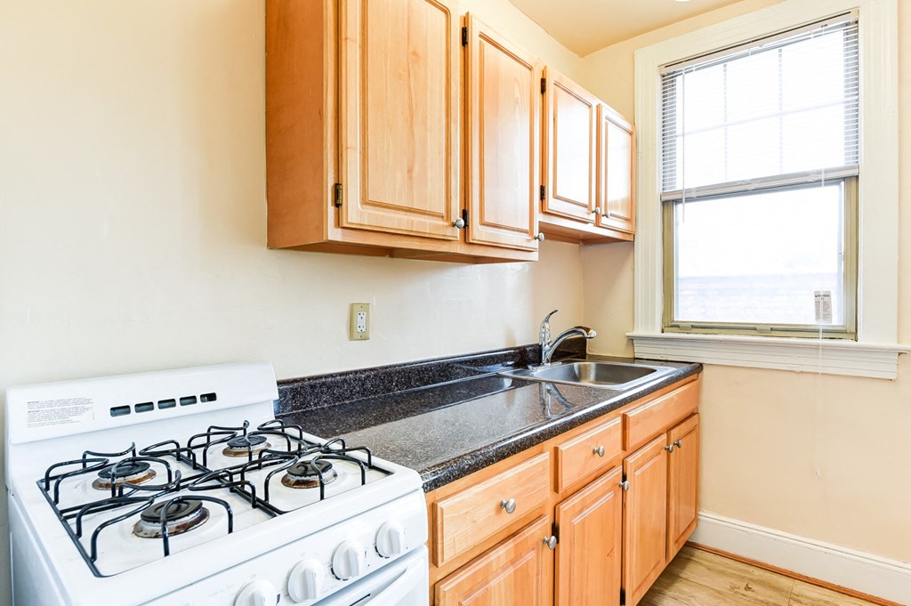 kitchen with gas range, wood cabinetry and energy efficient appliances at the foreland apartments in washinton dc