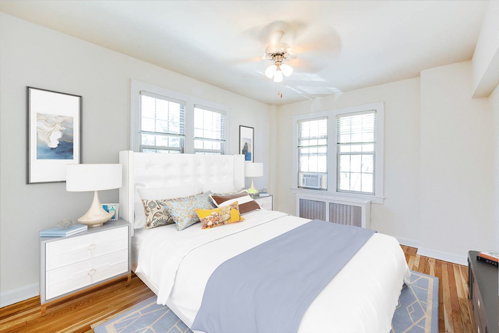 bedroom with bed, nightstands, large windows, hardwood flooring and ceiling fan at the frontenac apartments in washington dc