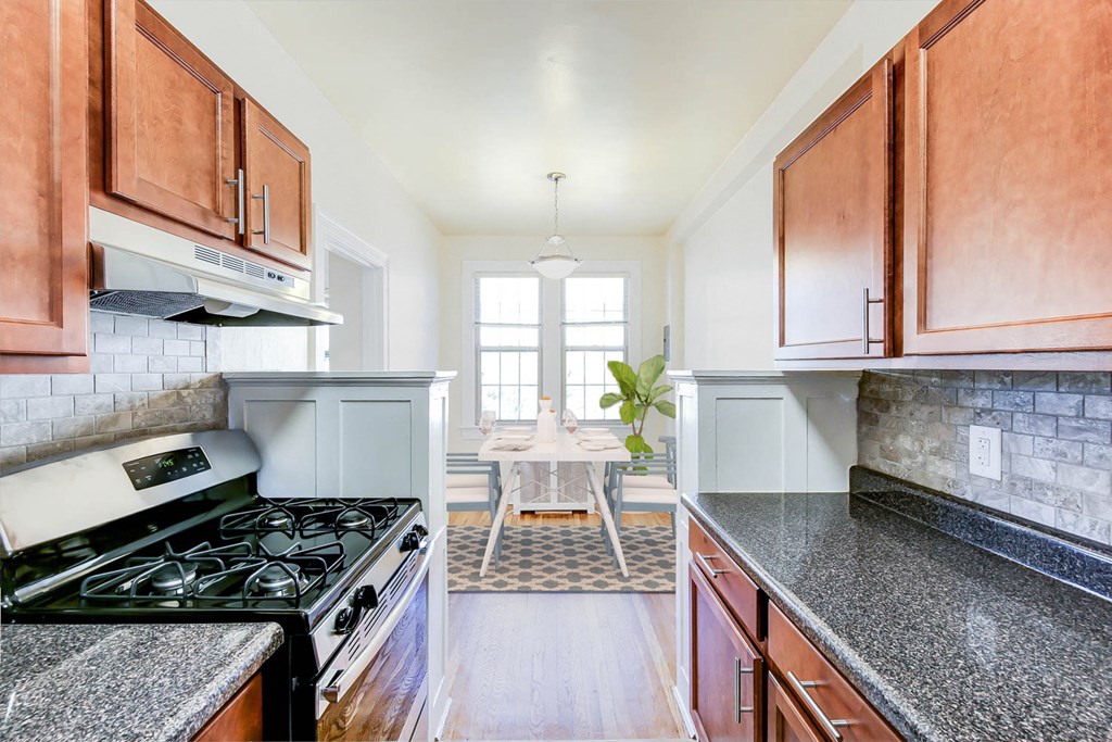kitchen with stainless steel appliances, modern countertops and view of dining area at the frontenac apartments in washington dc