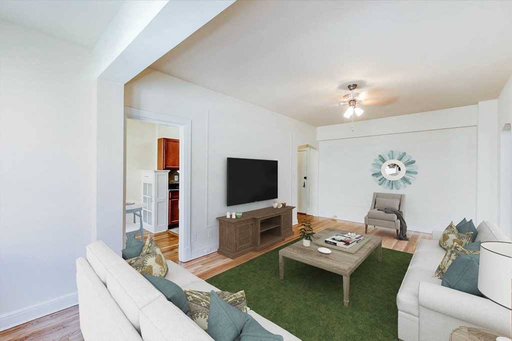 living area with sofa, coffee table, credenza, tv, ceiling fan and view of kitchen at frontenac apartments in washington dc.