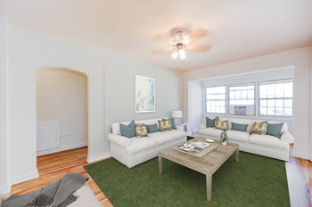 living area with sofa, coffee table, hardwood floors, ceiling fan and large windows at frontenac apartments in washington dc. - Photo Gallery 5