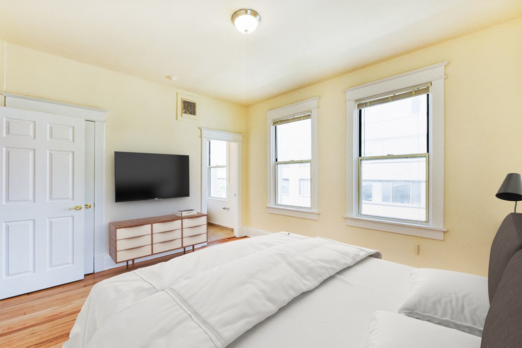 Bedroom with bed, dresser, tv, and large windows at twin oaks apartments columbia heights washington dc