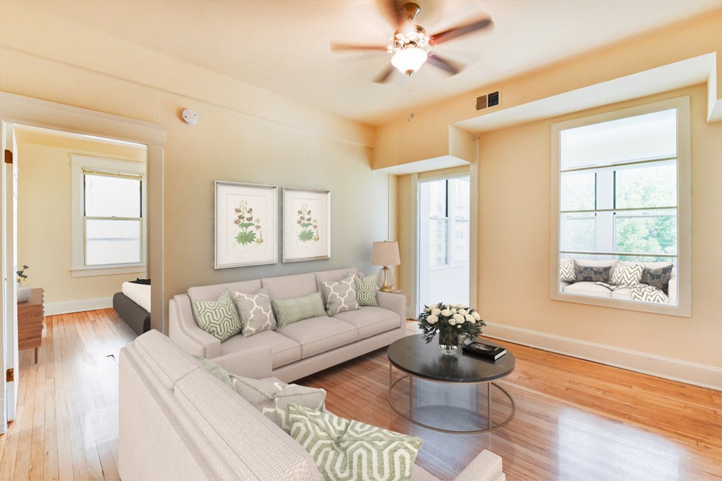 living area with large windows, sofa, coffee table, hardwood floors and view of sunroom at twin oaks apartments columbia heights washington dc