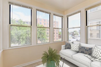 sunroom with sofa, coffee table and large windows at twin oaks columbia heights washington dc - Photo Gallery 6