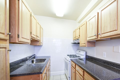 a kitchen with wood cabinets and granite counter tops and a stove and sink