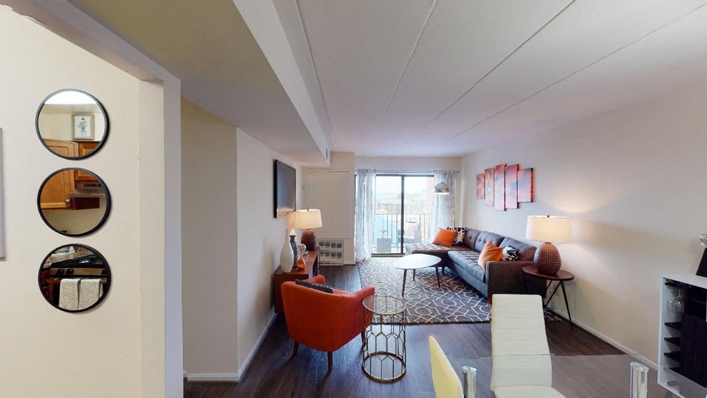 Livingroom with sofa, coffee table, decorative rug and view of balcony at washington view apartments in southeast dc
