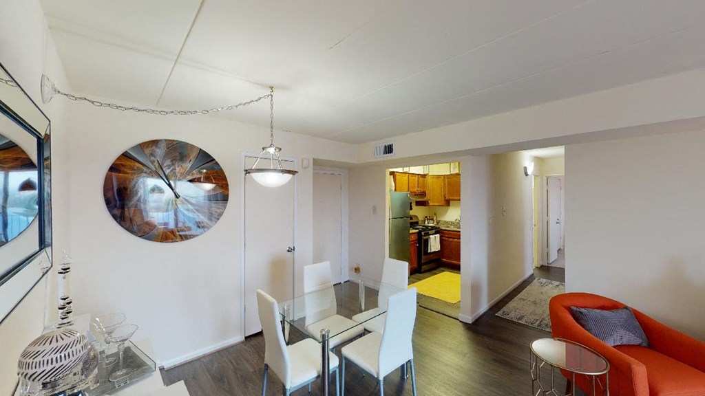 Dining area with table, chairs, decorative lighting, mirror and view of kitchen at washington view apartments in southeast dc
