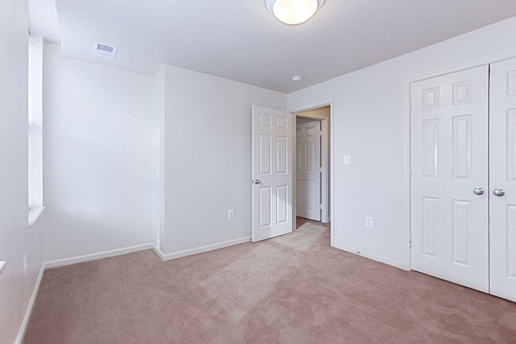 vacant bedroom with plush carpeting, windows and closet at whitelaw apartments in washington dc