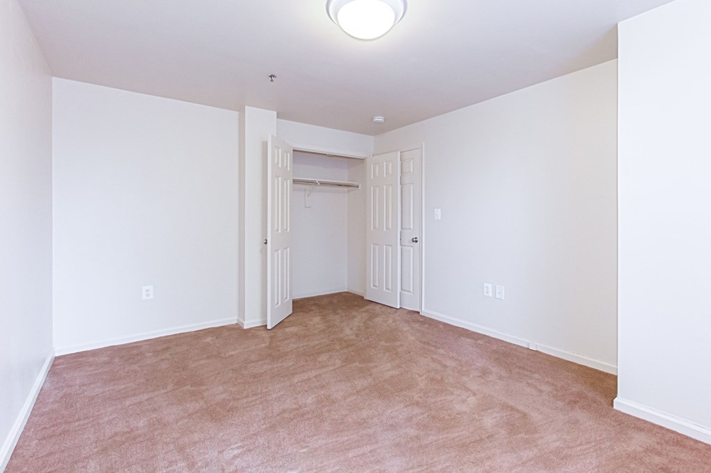 vacant bedroom with plush carpeting, windows and closet at whitelaw apartments in washington dc