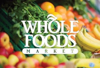 the whole foods market logo with a bunch of fruits and vegetables