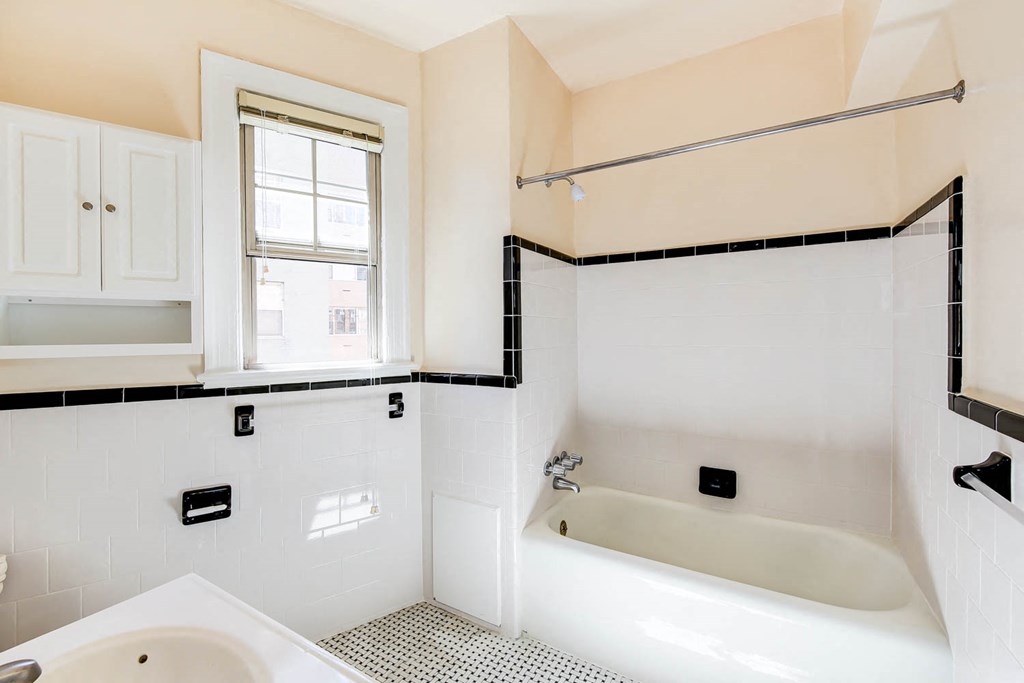 bathroom with tub, medicine cabinet and window at the frontenac apartments in van ness washington dc