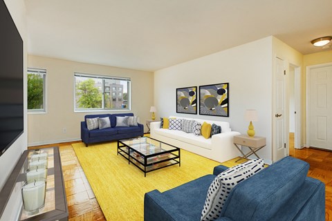 a living room with a yellow rug and blue and white furniture