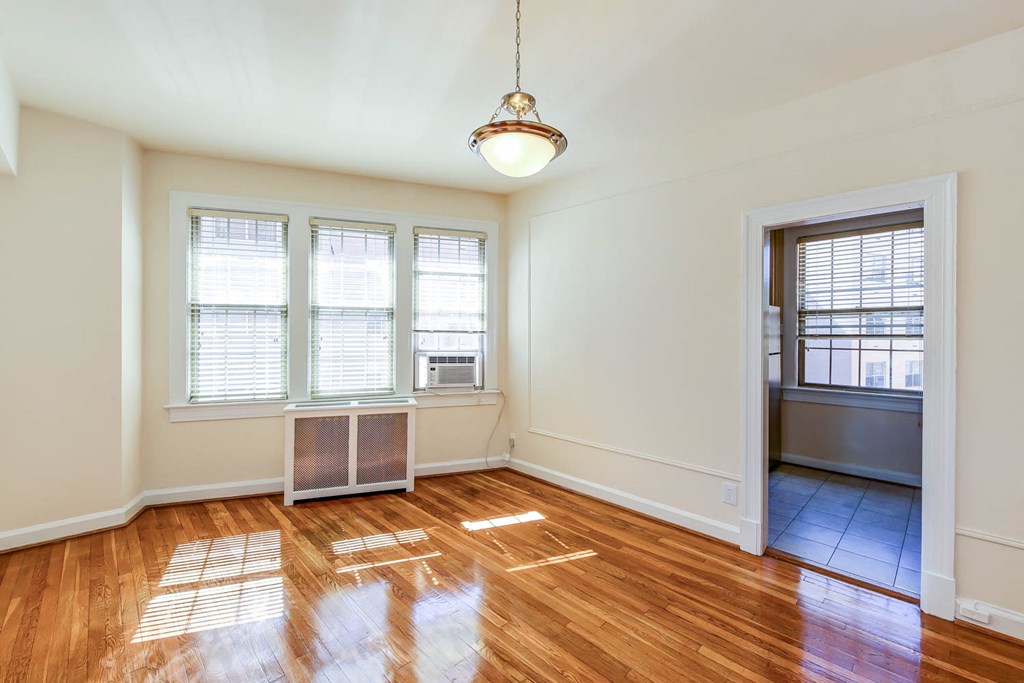 vacant dining toom with large windows and hardwood floors at the frontenac apartments in van ness washington dc